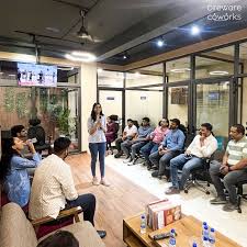 "Attendees participating in a workshop at a coworking space, engaging in a group discussion.